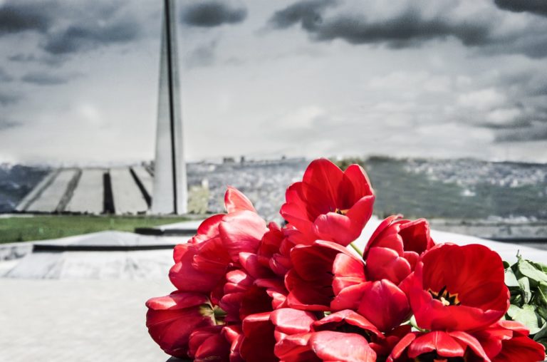 Red tulips in Tsitsernakaberd, Armenia with the Armenian genocide memorial in the background.